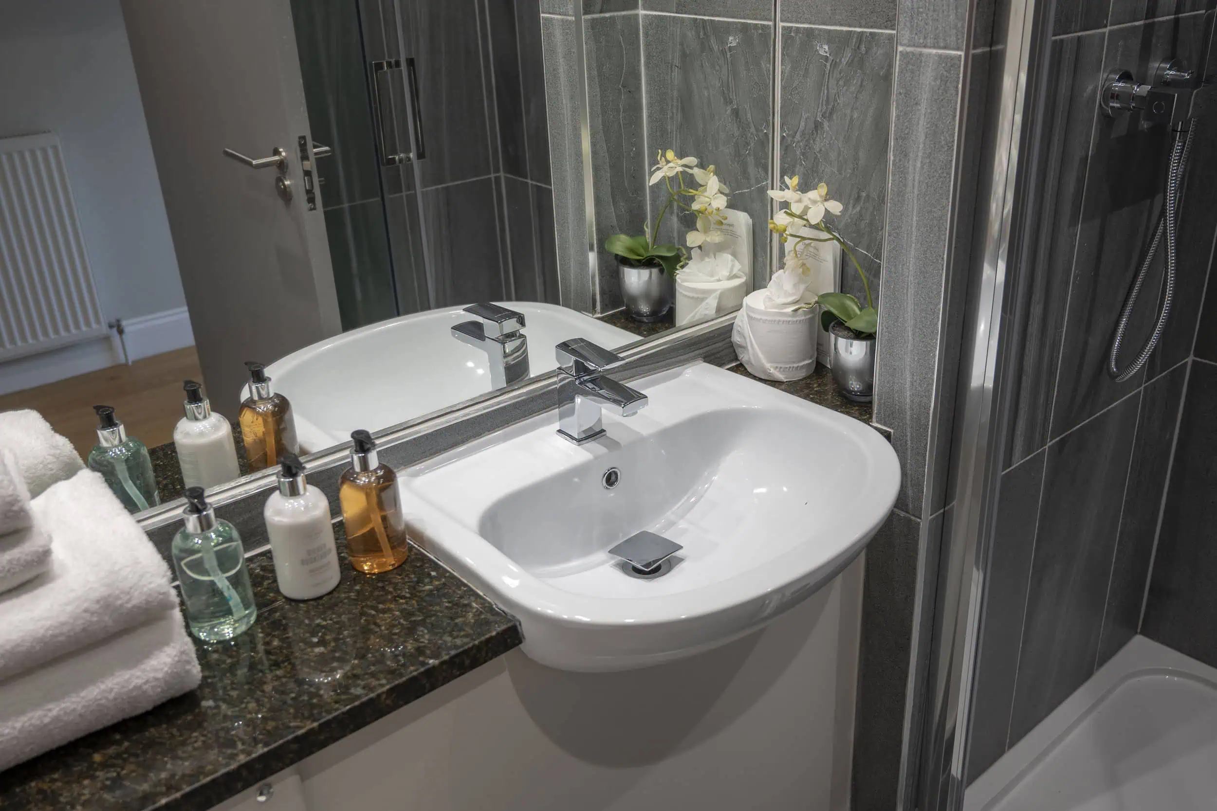 Shower room with handbasin shower and towels